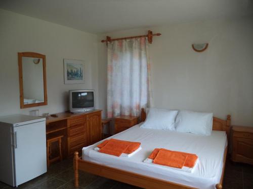 a bedroom with a bed with two orange towels on it at Victoria Sinemorets Guest House in Sinemorets