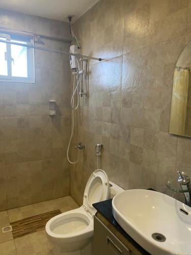 a bathroom with a shower and a toilet and a sink at El Puerto Marina Beach Resort & Vacation Club in Lingayen