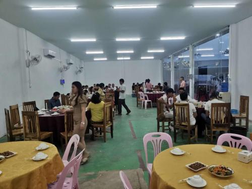 een groep mensen die aan tafel zitten in een restaurant bij 华泰酒店HUA TAI HOTEL in Vang Vieng