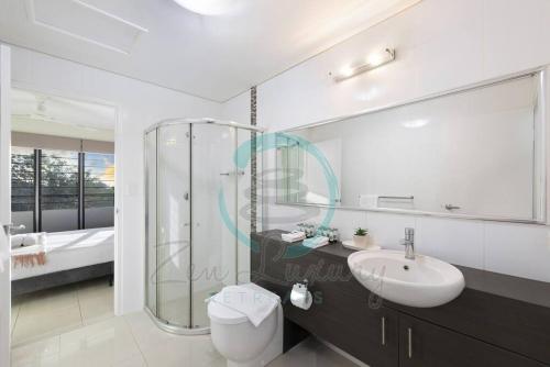 y baño con lavabo, ducha y aseo. en Zen on Stuart: 3-BR Penthouse Pad + Pool + BBQ, en Stuart Park