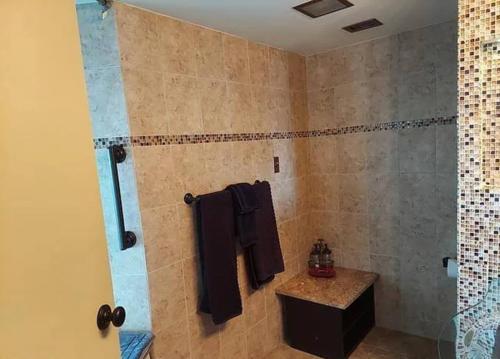 ein Bad mit einer Dusche, schwarzen Handtüchern und einem Waschbecken in der Unterkunft Beach Front with Ocean View in Atlantic City