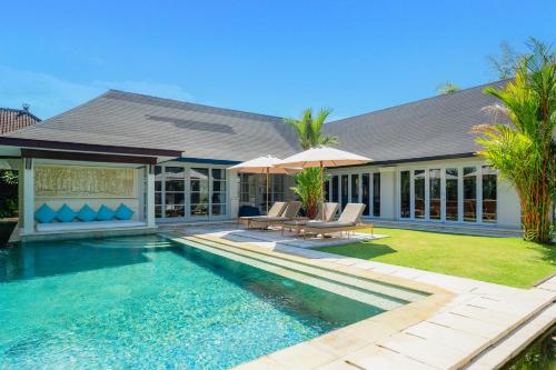 a house with a swimming pool and a house at The Zen Villas in Sanur