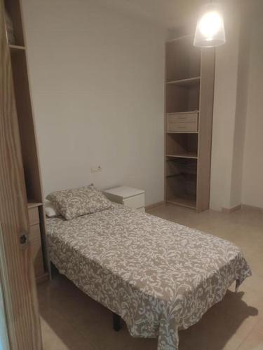 - une petite chambre avec un lit et une lampe dans l'établissement Tranquilo apartamento de pueblo, à Benifairó de Les Valls