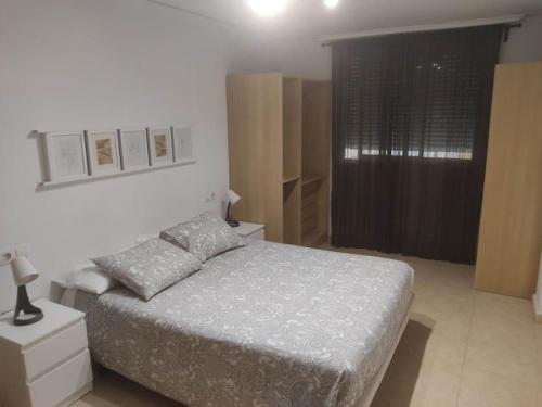 - une chambre blanche avec un lit et une fenêtre dans l'établissement Tranquilo apartamento de pueblo, à Benifairó de Les Valls