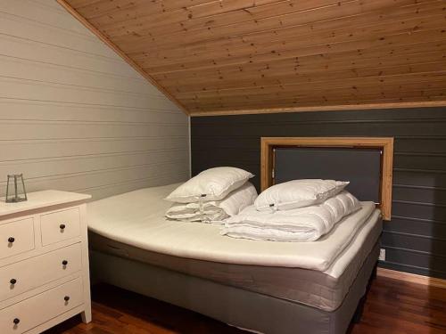 Bett in einem Zimmer mit Holzdecke in der Unterkunft Flott rorbu på idylliske Langevåg/Bømlo in Bømlo