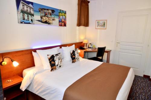 a hotel room with a bed and a desk at Hôtel du Fort in Meulan