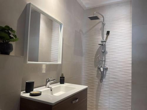 y baño con lavabo y ducha con espejo. en Super studio confortable en Casablanca