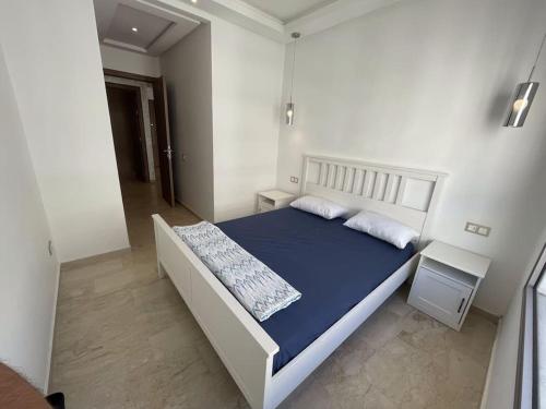1 dormitorio con 1 cama grande con sábanas y almohadas azules en Super studio confortable en Casablanca