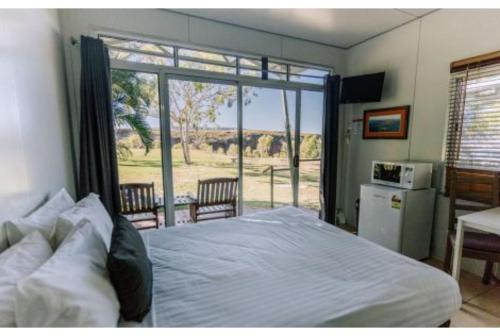 a bedroom with a bed and a large window at Discovery Resorts - Lake Argyle 