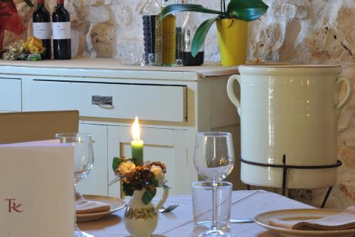 un tavolo con una candela e bicchieri di vino sopra di Masseria Triticum a Francavilla Fontana