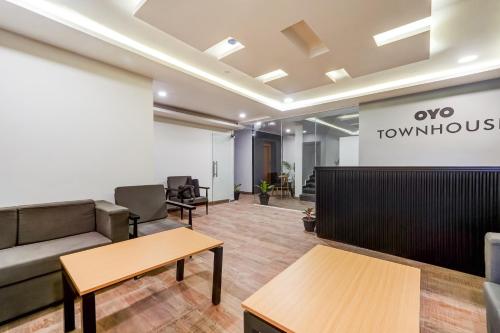 an office lobby with a couch and tables at Townhouse De Alphabet Tirupati in Tirupati