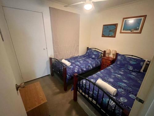 1 Schlafzimmer mit 2 Betten und einer Tür zu einem Zimmer in der Unterkunft The Orchid Courthouse - Busselton in Geographe