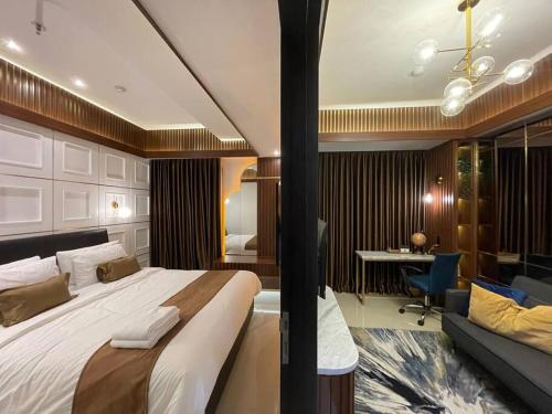 ein Hotelzimmer mit einem großen Bett und einem Schreibtisch in der Unterkunft The Best Merapi View Apartment By Kinasih Suites in Ngaglik