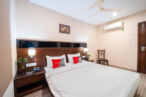 ein Schlafzimmer mit einem großen weißen Bett mit roten Kissen in der Unterkunft Eco Stay by Playsales in Indore