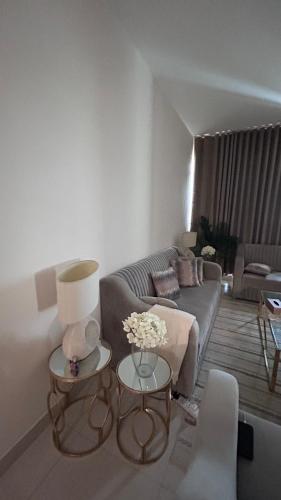 uma sala de estar com um sofá e duas mesas em Love place em Abu Dhabi