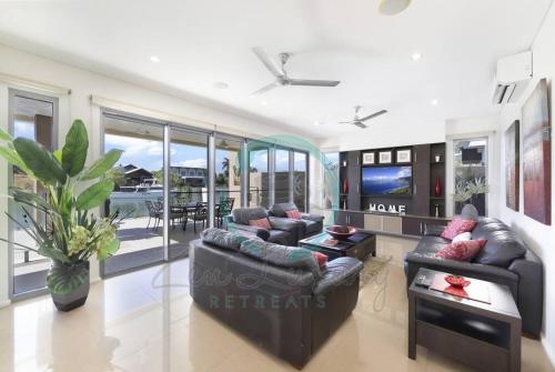 a living room with two couches and a television at Zen Bayview Bliss: Luxury Marina Mansion in Stuart Park