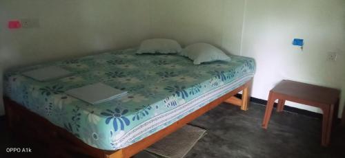 a small bed in a room with a table at Green House Yala in Kirinda