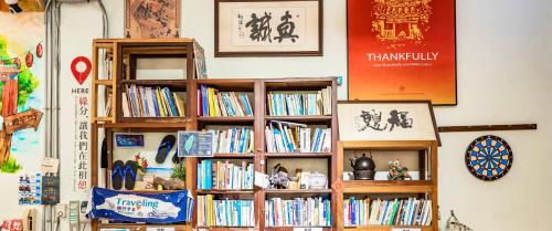 a book shelf filled with books on a wall at Fuqi Hostel - Yuanqi in Tainan