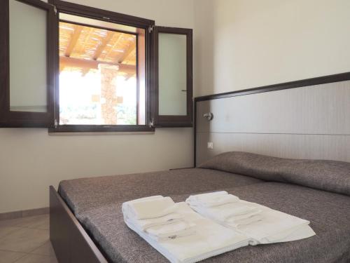 Una cama con dos toallas blancas encima. en Agriturismo Casa del Peperoncino en Otranto