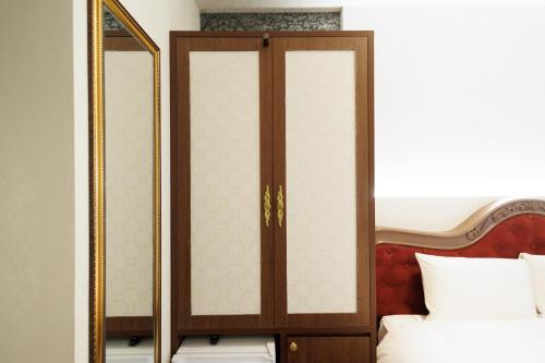 a wardrobe with a mirror next to a bed at Hotaku HOTEL - Vacation STAY 98852v in Tokyo