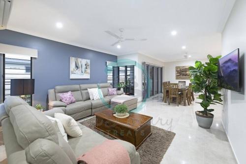 a living room with a couch and a table at Zenhouse: 4BR Stylish Work/Family Home in Muirhead in Leanyer