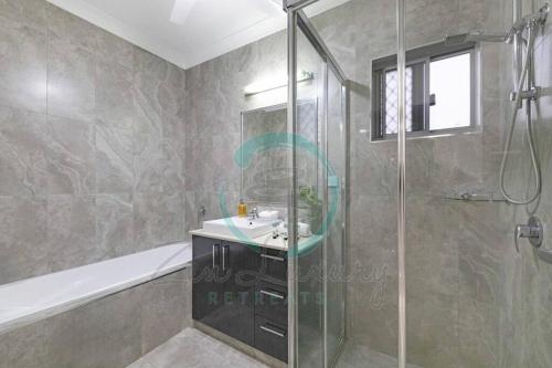 a bathroom with a shower and a sink and a tub at Zenhouse: 4BR Stylish Work/Family Home in Muirhead in Leanyer