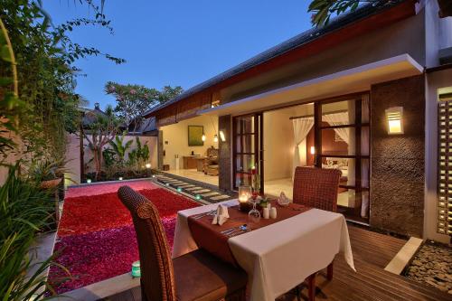 a dining area with a table and chairs in a house at Lumbini Luxury Villas and Spa in Jimbaran
