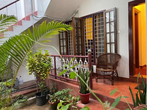 a balcony of a house with plants and a chair at Walton's Homestay, Fort Cochin in Fort Kochi