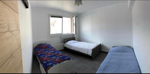 a small bedroom with two beds and a window at Bel appartement cosy très calme avec parking privé in Templemars