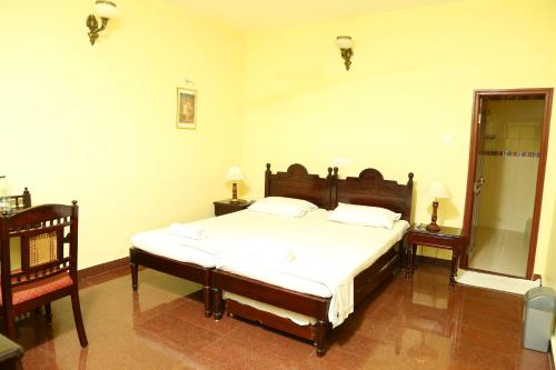 a bedroom with a bed and two tables and a mirror at Walton's Homestay, Fort Cochin in Fort Kochi