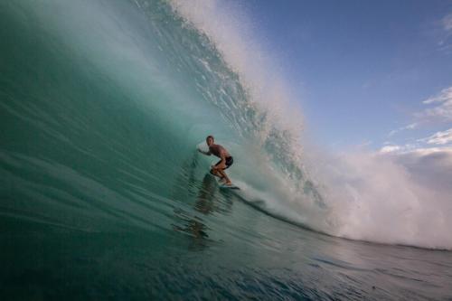 a man riding a wave on a surfboard in the ocean at Sumatra Surf Resort in Biha