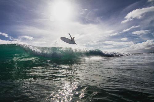 a person riding a wave on a surfboard in the ocean at Sumatra Surf Resort in Biha