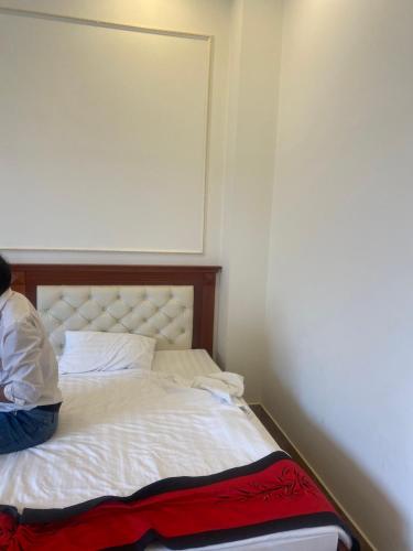 una persona sentada en una cama en una habitación en Mekong gia lai hotel, en Plei Brel (2)