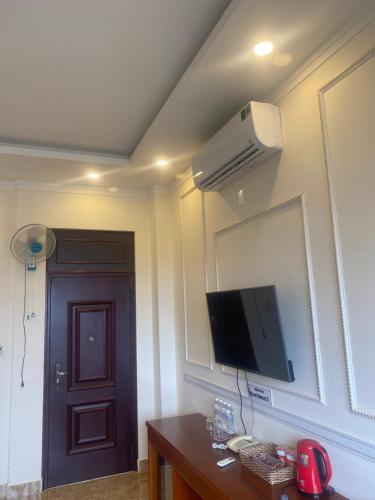 Pokój z telewizorem na ścianie i drzwiami w obiekcie Mekong gia lai hotel w mieście Plei Brel (2)