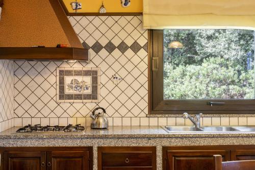 eine Küche mit einem Waschbecken und einem Fenster in der Unterkunft Villa Maria Antonietta in Sassari