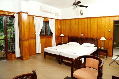 a bedroom with two beds and wooden walls at Walton's Homestay, Fort Cochin in Fort Kochi