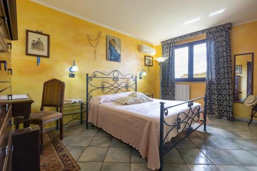 a bedroom with a bed and a table and a window at Villa Maria Antonietta in Sassari