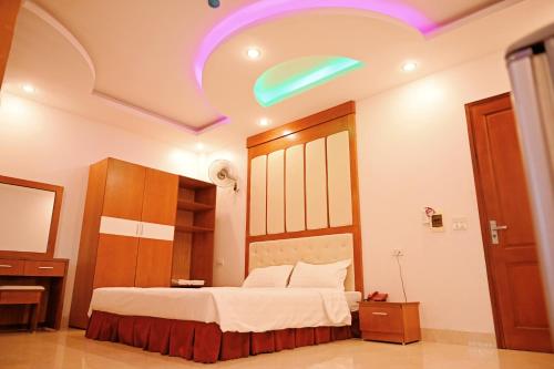 a bedroom with a large bed with a green ceiling at Khách sạn Hoàng Hà River Town in Yên Bái
