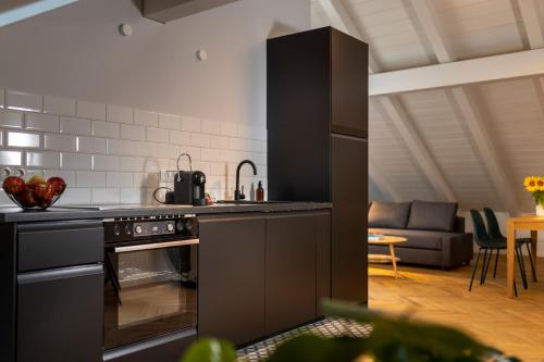 a kitchen with a stove top oven next to a living room at fil HOME in Leisach
