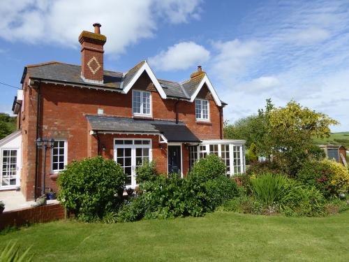 a brick house with a clock tower on top of it at Pump Cottage in Weymouth