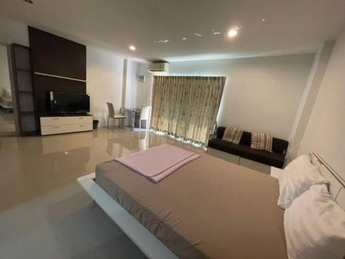 a bedroom with a large bed and a living room at BKK TEAK Hostel in Amphoe Phra Khanong