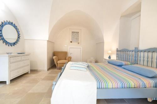 a bedroom with two beds and a dresser and a mirror at Agrumeto sul mare in Ostuni