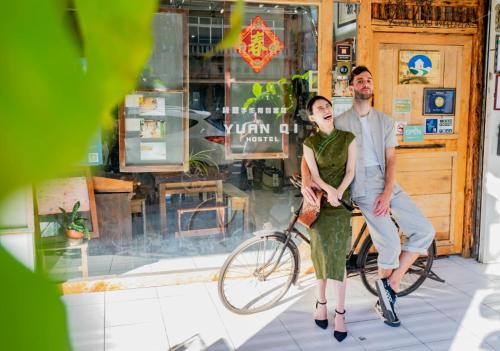 a man and a woman sitting on a bike at Fuqi Hostel - Yuanqi in Tainan