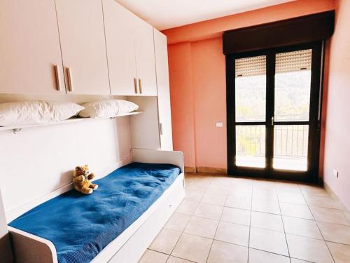 um urso de peluche sentado numa cama num quarto em Bianchi &Bianchi casa vacanza Laveno-Mombello em Laveno