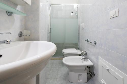 bagno bianco con lavandino e servizi igienici di Blu Mare a Otranto