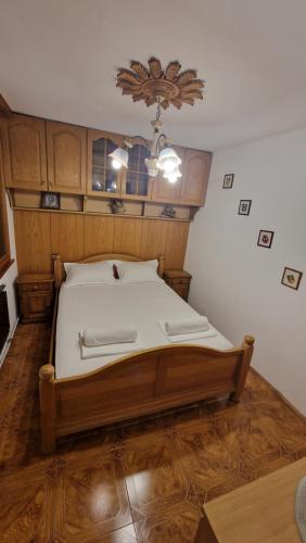 a bedroom with a bed with a wooden headboard at Къща за гости Великите in Veliko Tŭrnovo