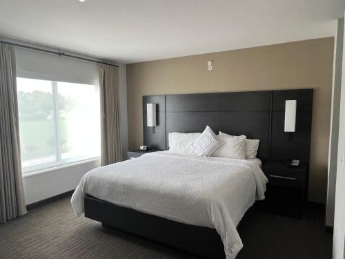 - une chambre avec un grand lit et une grande fenêtre dans l'établissement Residence Inn by Marriott Lafayette, à Lafayette