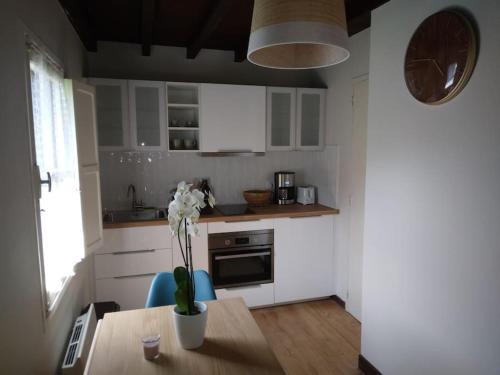 une cuisine avec une table avec un vase de fleurs dessus dans l'établissement La dépendance, à Luchon
