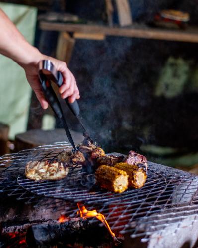 a person is cooking food on a grill at Experience accommadation Eco-Unela in Rovaniemi
