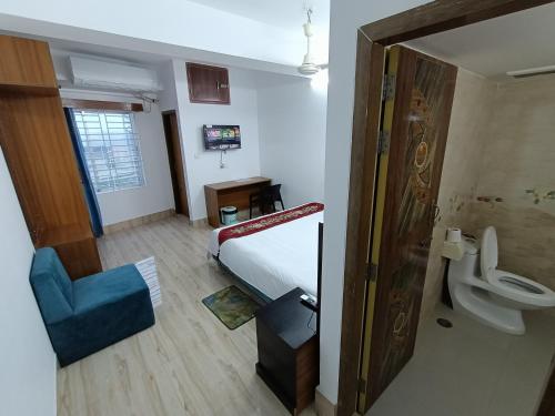 ein Schlafzimmer mit einem Bett und ein Badezimmer mit einem WC in der Unterkunft Hotel D-Palace in Dhaka